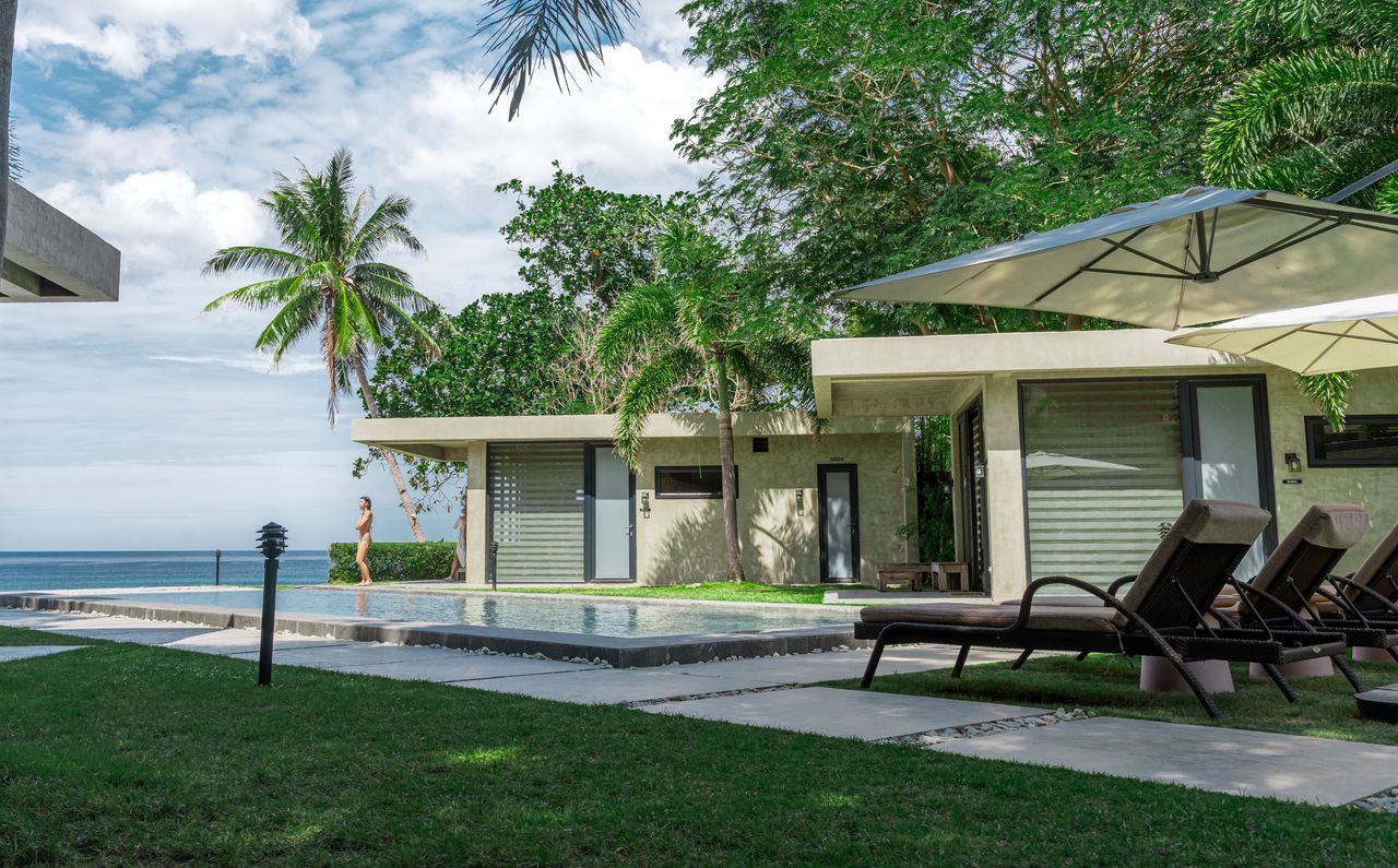 A cabin and loungers on the open lawn beside the pool at Veue