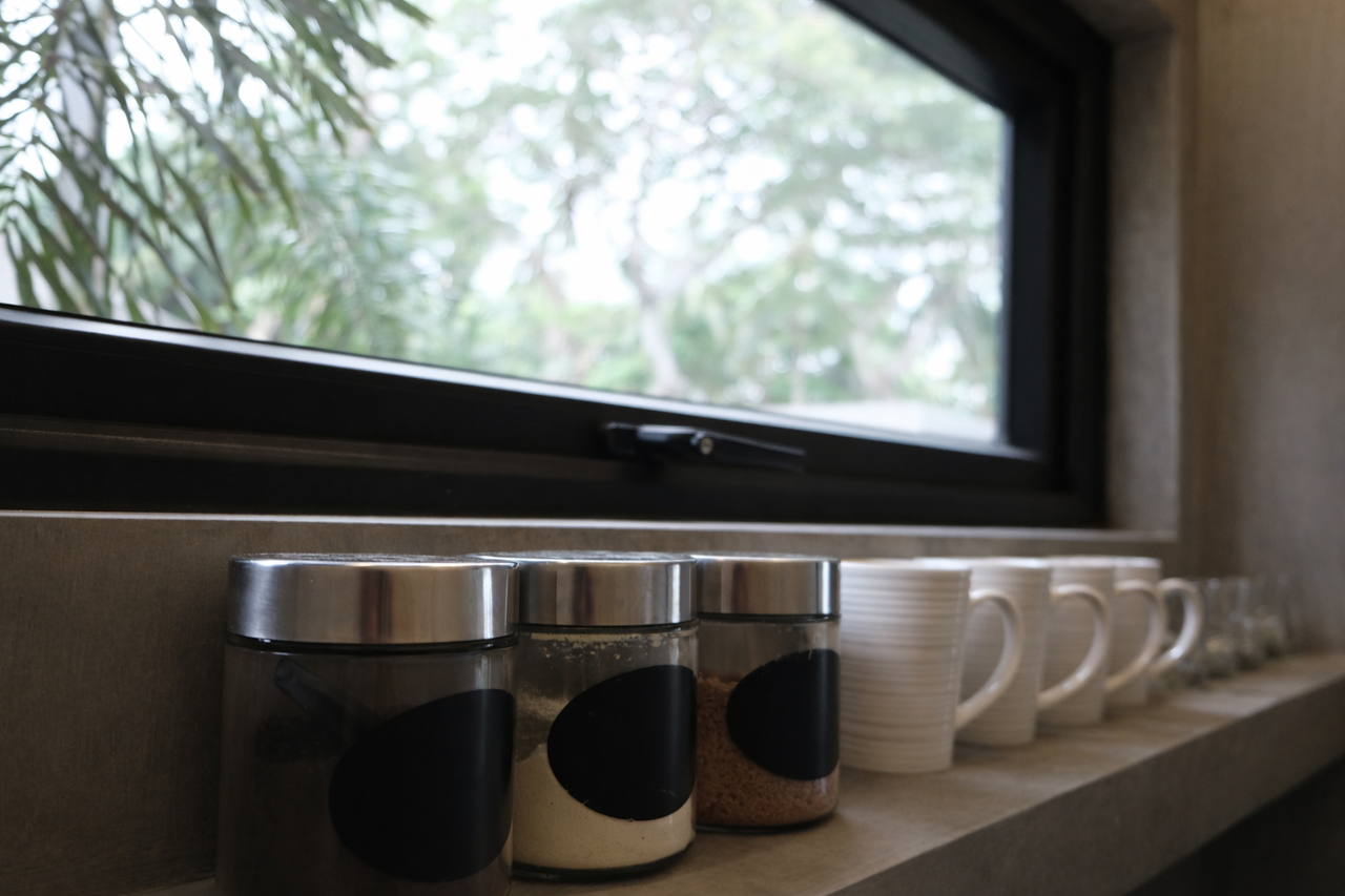 Storage canisters and mugs on a kitchen shelf in a Shoreline cabin