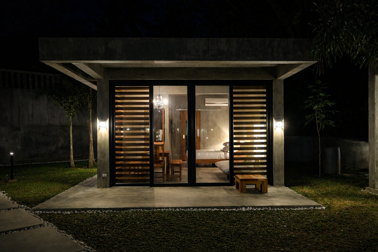 A Shoreline cabin at night with adjustable wood-slat blinds over the glass doors