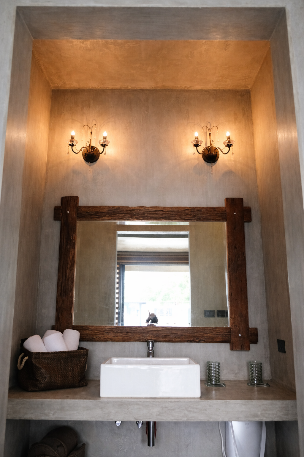 A wood-framed mirror over a vessel sink and vanity with towels in a Shoreline bathroom