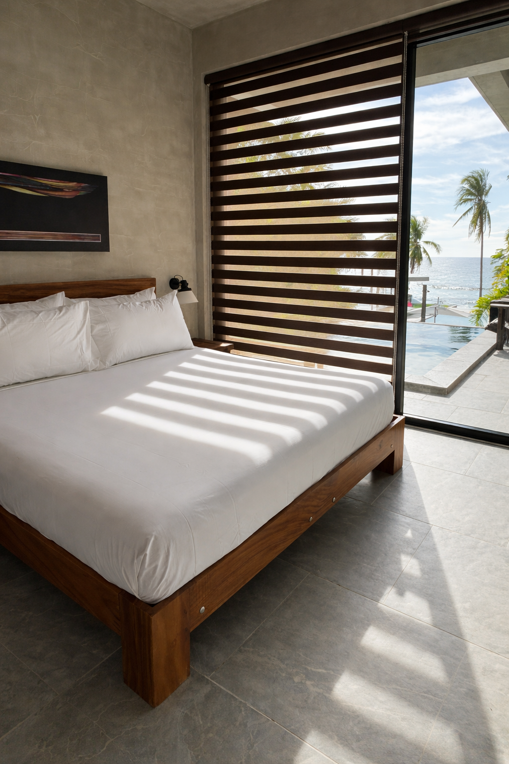 A king-size bed in a Horizon bedroom with the sea framed through the glass