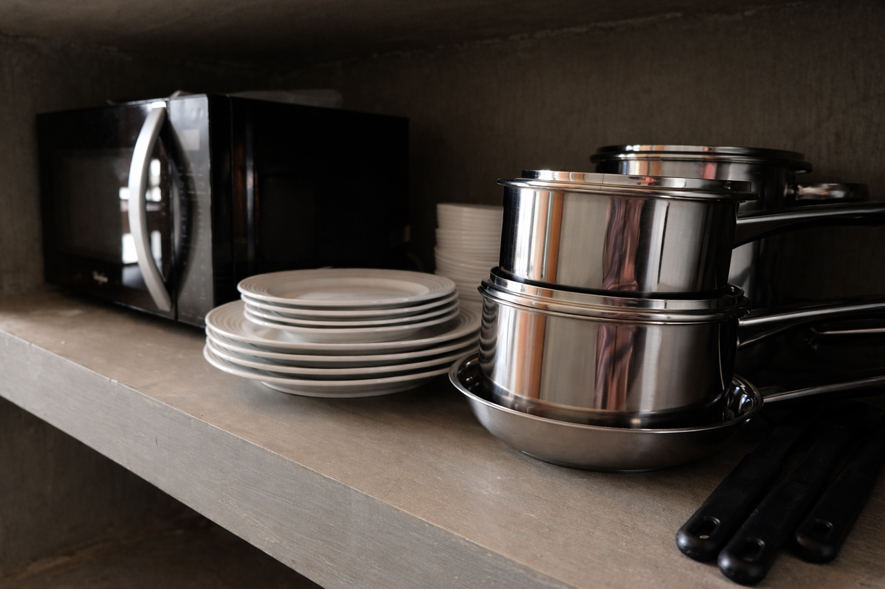 The cabin kitchen stocked with pots, pans, plates, and a microwave