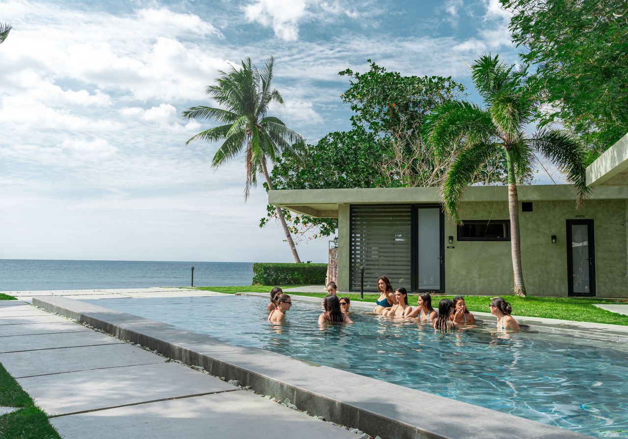 Guests relaxing on the underwater bench in the pool at Veue