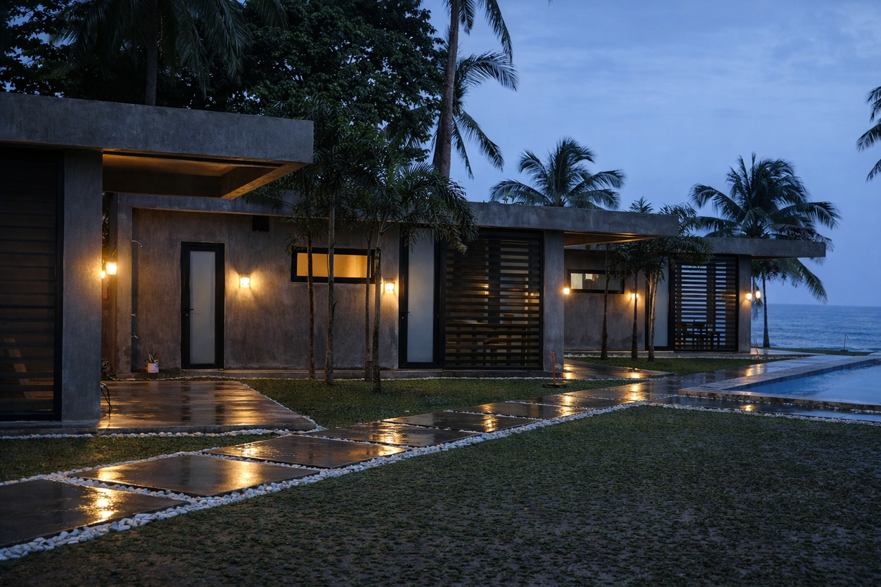 The cabins at dusk after rain, wet paths glowing under the wall lamps