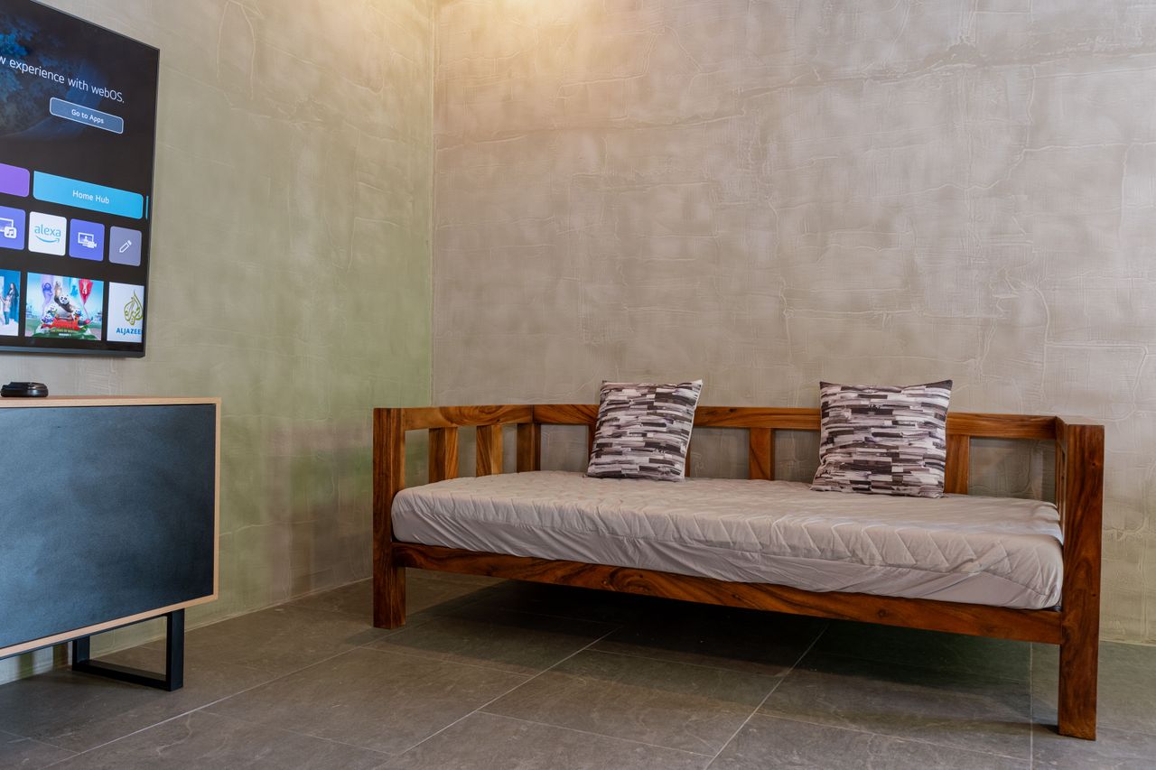 A wooden daybed facing the Smart TV in a Horizon living area