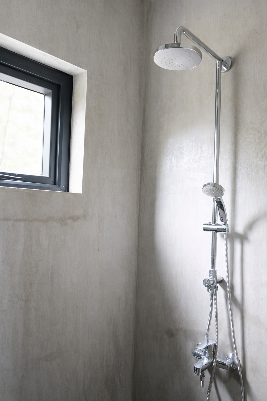 A walk-in shower with a rain head and handheld sprayer in a Shoreline cabin