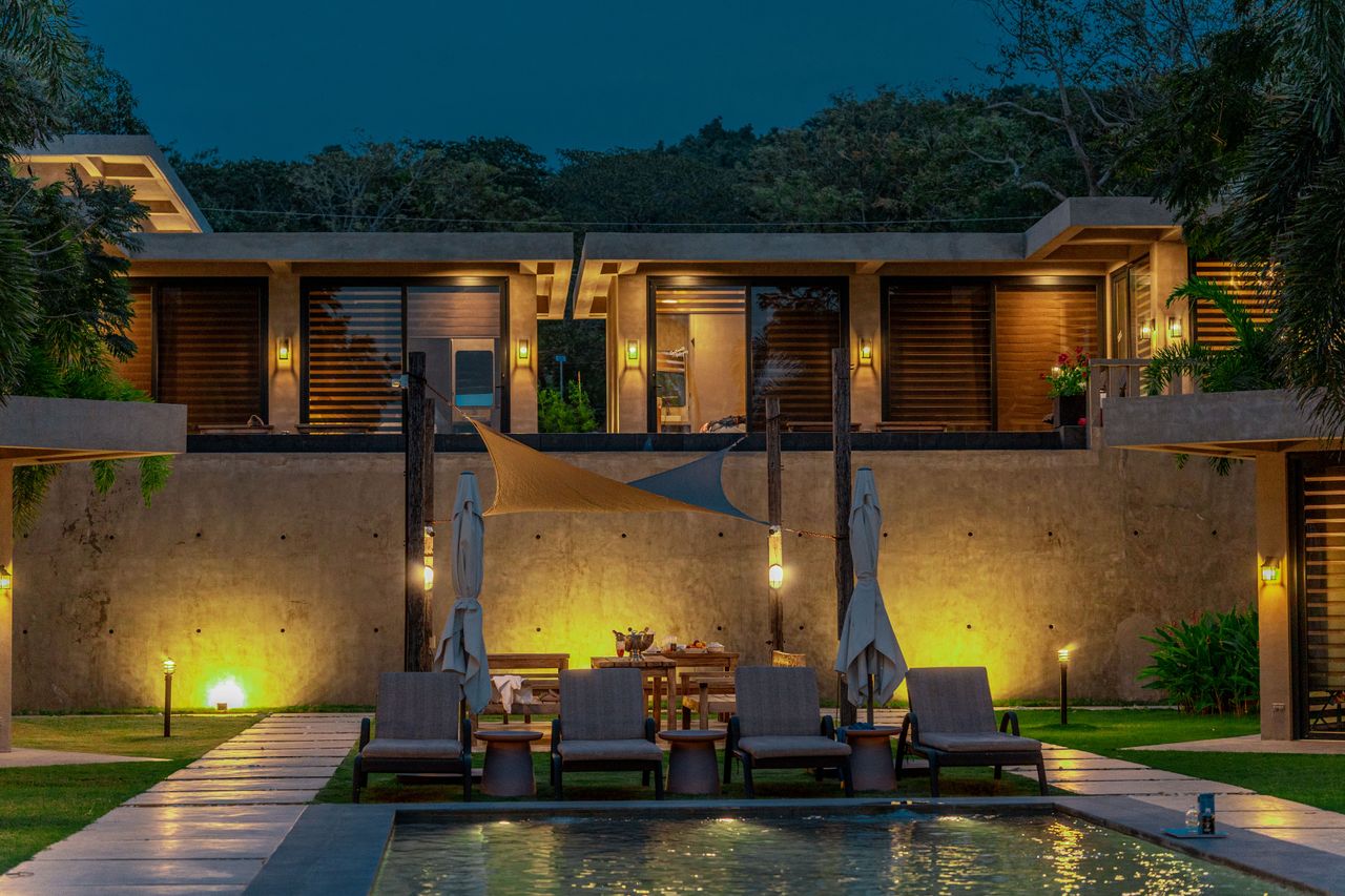 The two-story Horizon cabins lit at dusk, Marcel and Maramag above the pool