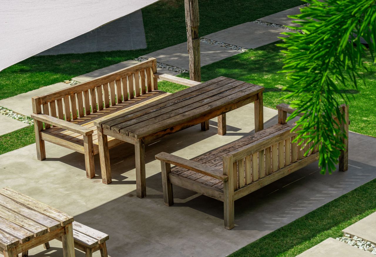 Solid wood benches and table on a concrete patio at Veue