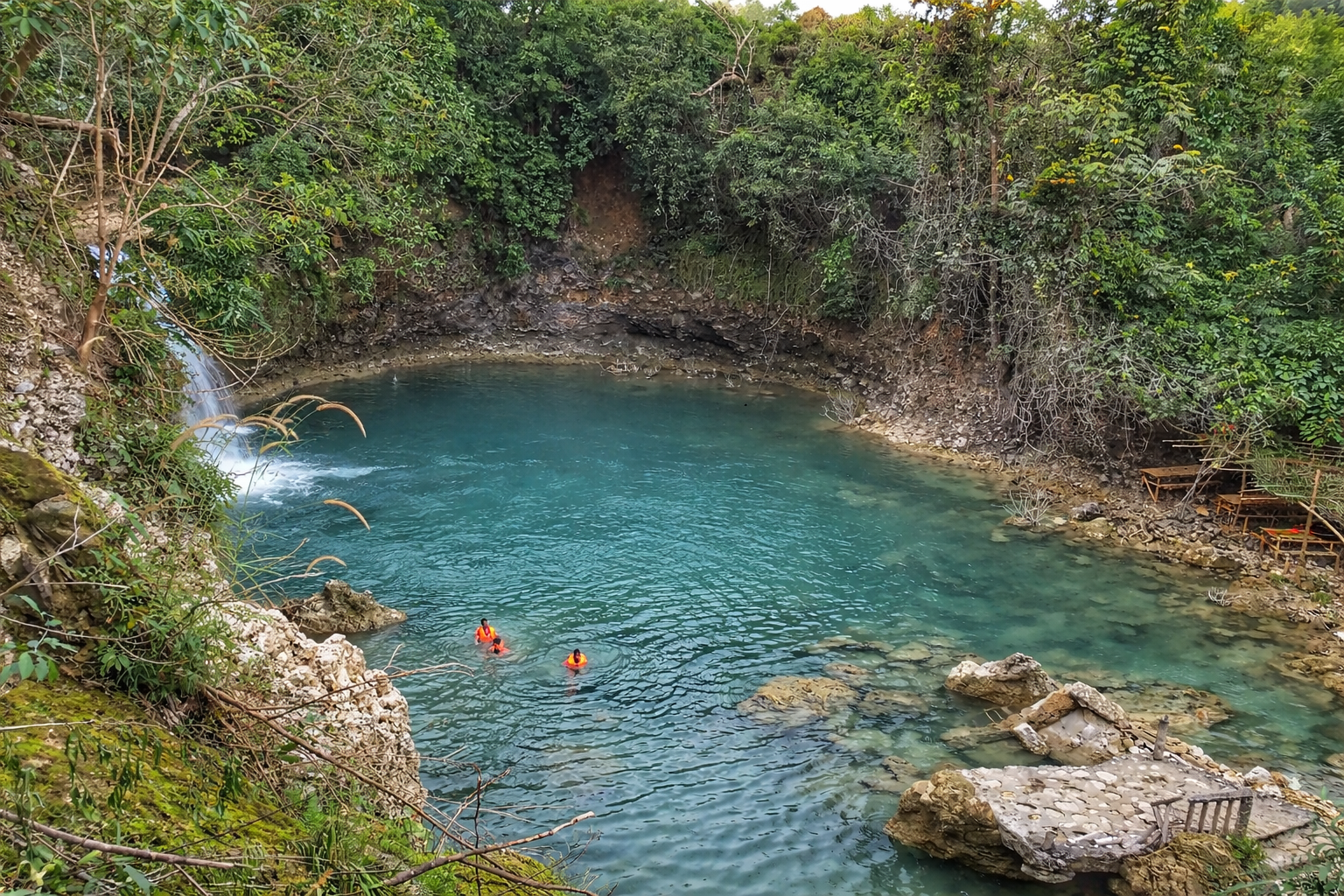 Swimmers floating in the clear, cool pool at the base of Bolinao Falls.