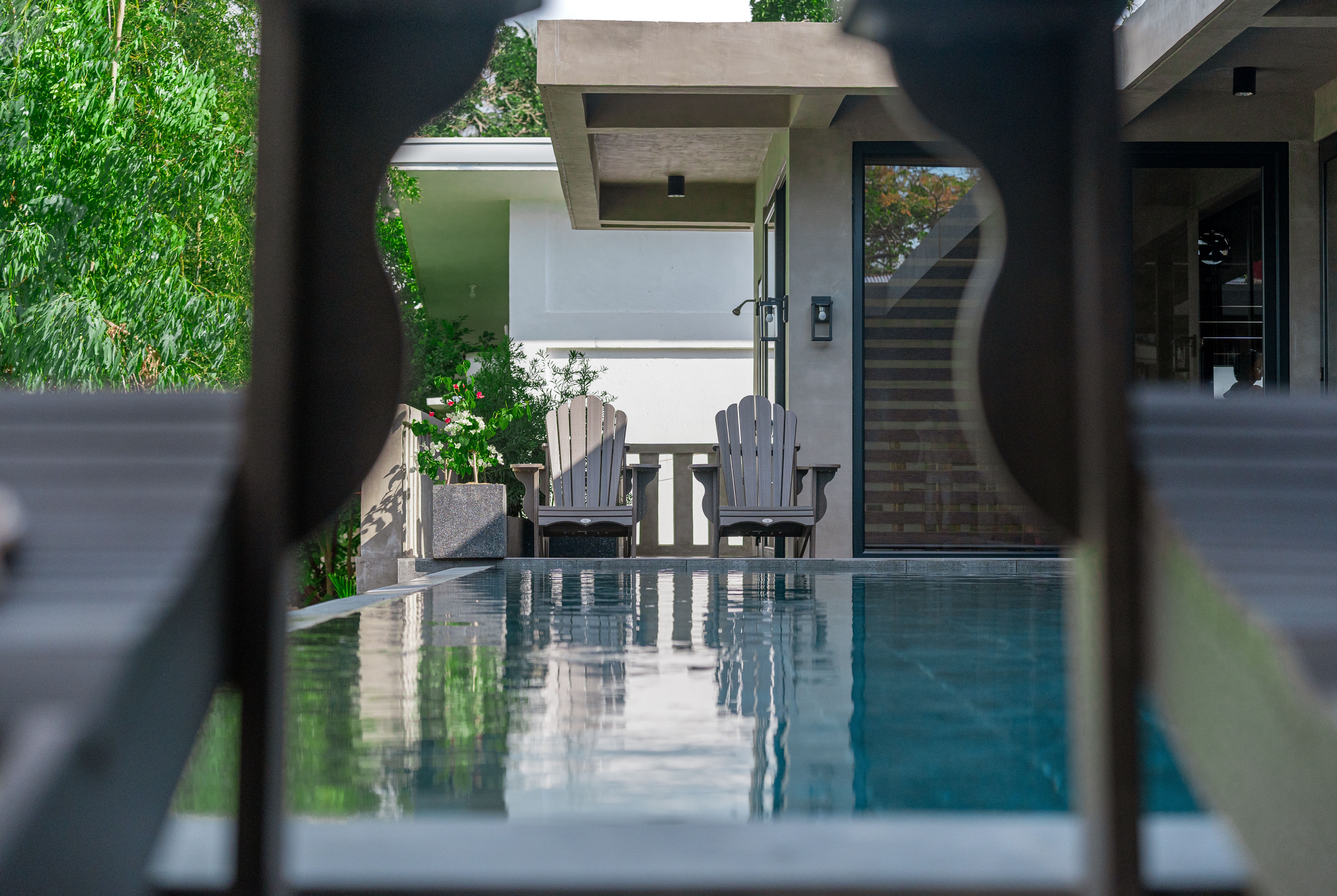 Adirondack chairs by the Horizon infinity pool framed through a chair back