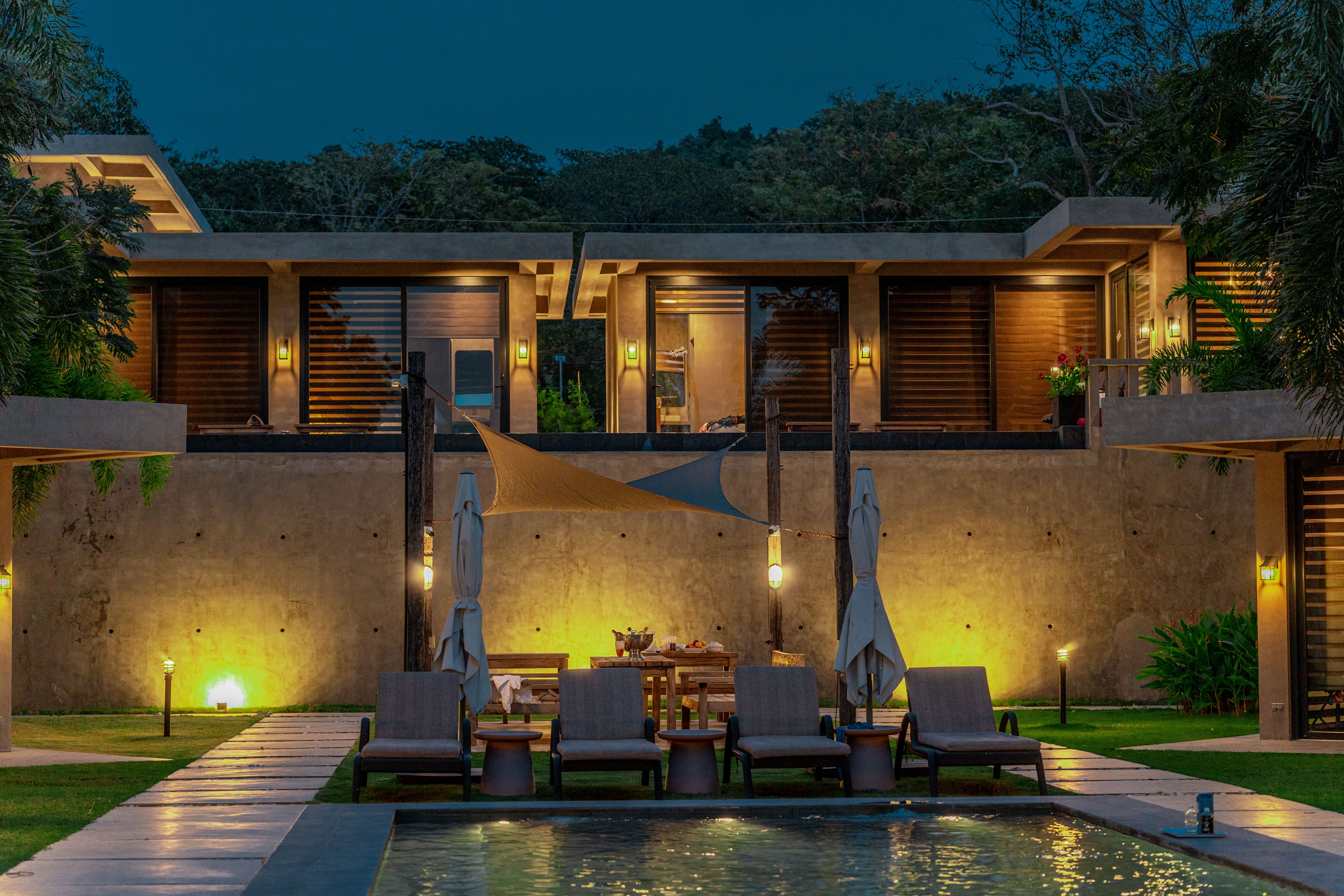 The two-story Horizon cabins lit at dusk, Marcel and Maramag above the pool
