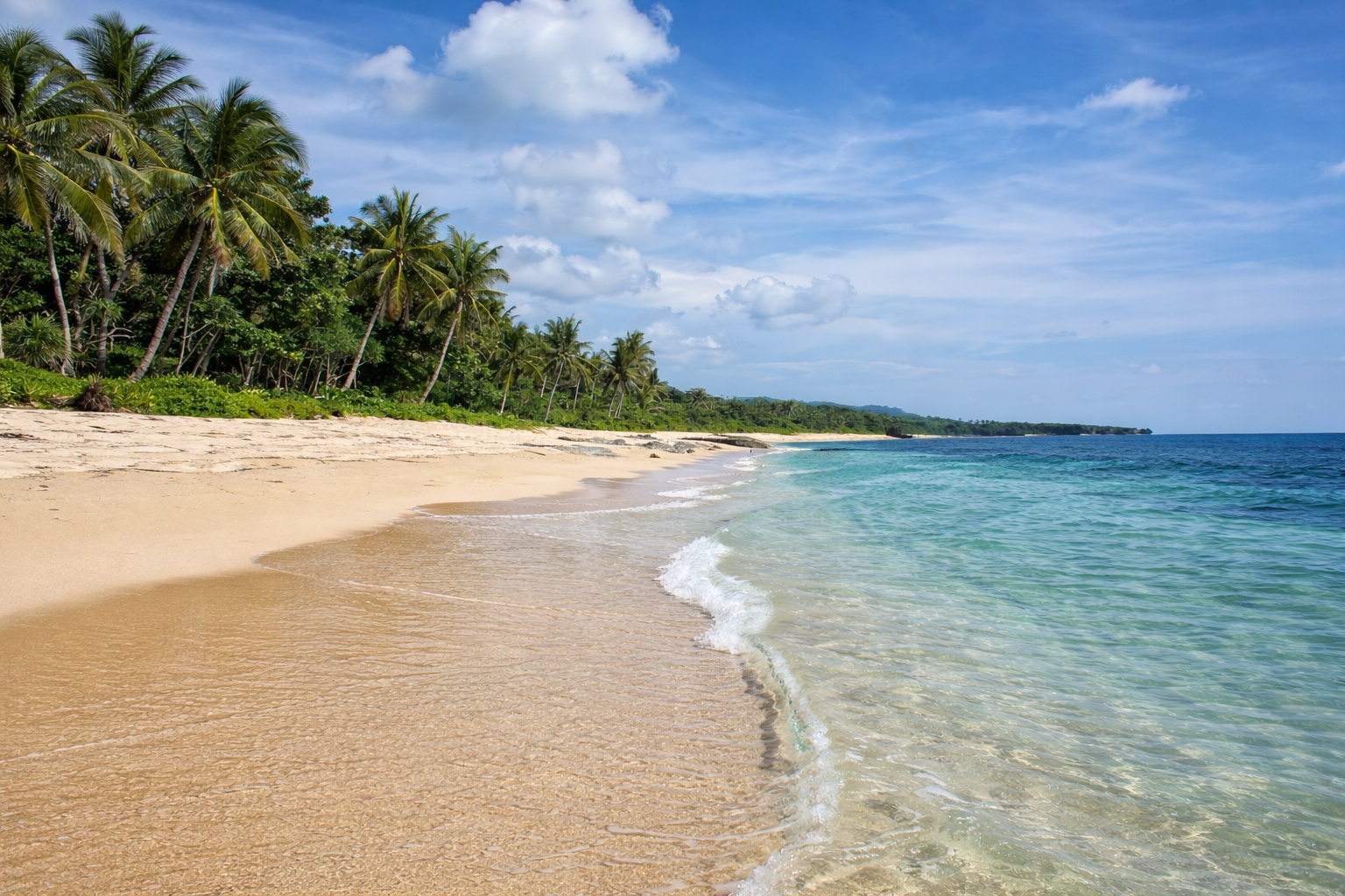 A small, empty cove near Patar Beach, Bolinao, with pale sand and clear water, the kind of beach you reach by walking or by boat.